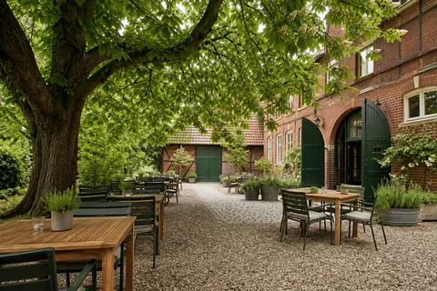 Die Gartenterrasse unter der alten Kastanie am hellen Sommertag.